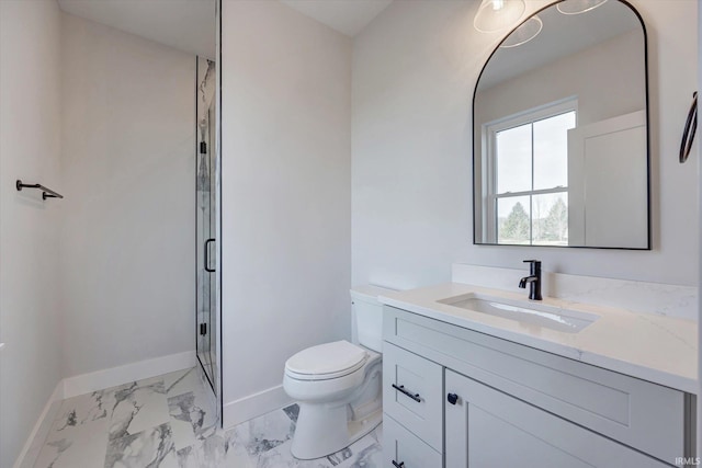 bathroom featuring vanity, a shower with shower door, and toilet