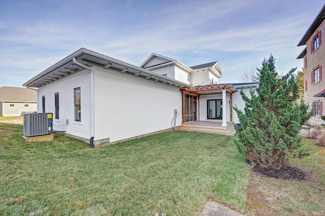 view of front facade featuring cooling unit, a pergola, and a front lawn