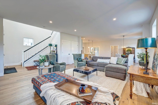 living room with light hardwood / wood-style flooring and an inviting chandelier