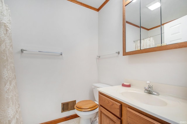 bathroom with toilet, vanity, and crown molding