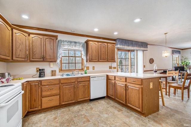 kitchen featuring kitchen peninsula, pendant lighting, sink, white appliances, and ornamental molding