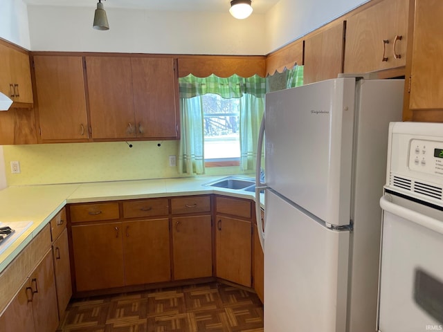 kitchen with white appliances and dark parquet flooring