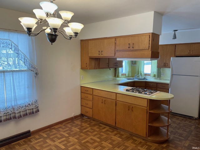 kitchen with kitchen peninsula, hanging light fixtures, white appliances, a notable chandelier, and dark parquet floors