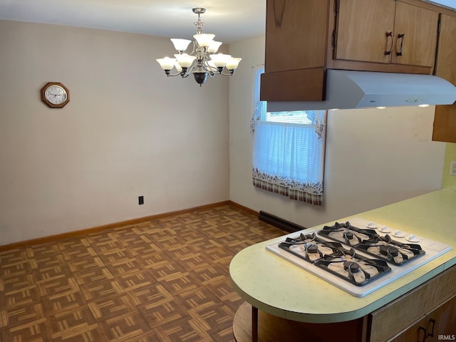 kitchen with white gas stovetop, extractor fan, hanging light fixtures, an inviting chandelier, and dark parquet flooring