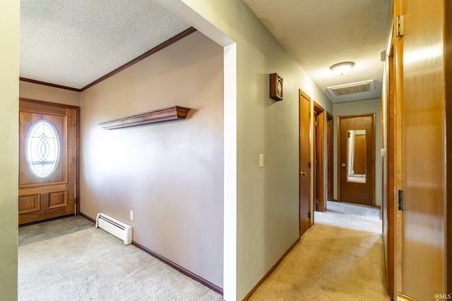 entryway with a baseboard radiator, a textured ceiling, and light colored carpet