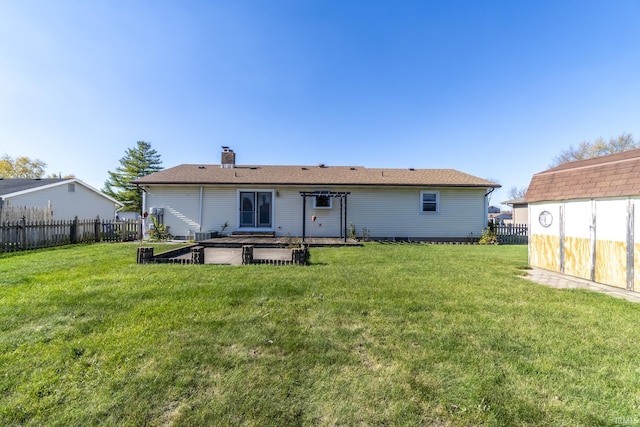 back of house featuring a yard and central AC