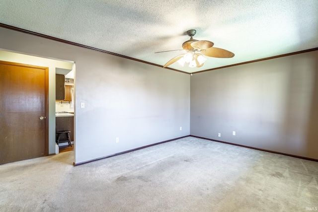 unfurnished room with ceiling fan, light colored carpet, a textured ceiling, and crown molding