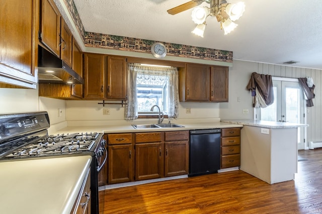 kitchen with sink, black appliances, a textured ceiling, and dark hardwood / wood-style flooring