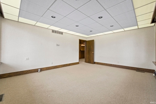 spare room featuring carpet and a paneled ceiling