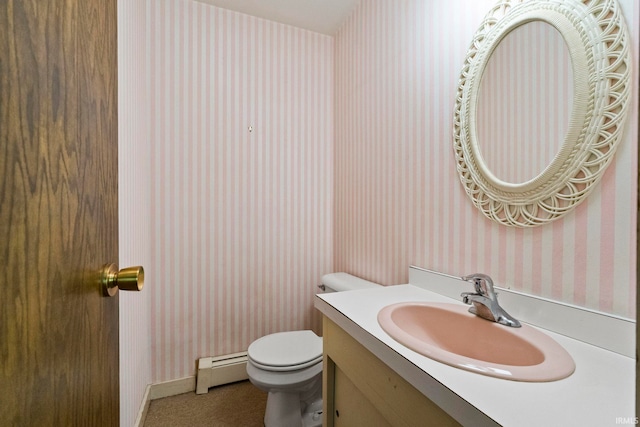 bathroom with a baseboard heating unit, vanity, and toilet