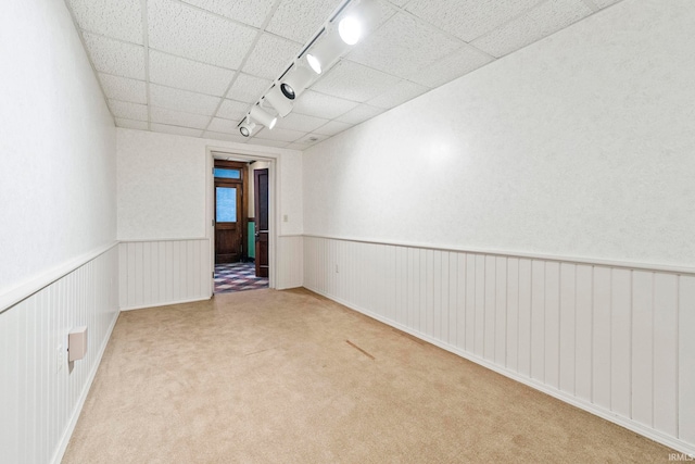 unfurnished room with light colored carpet and rail lighting