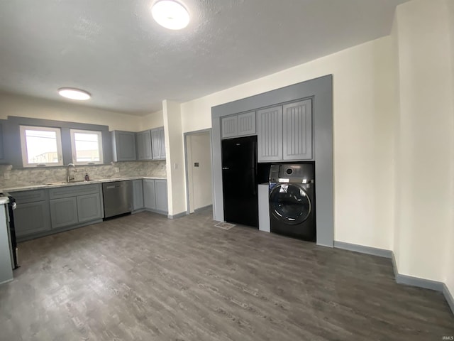 kitchen with washer / clothes dryer, dark wood-type flooring, sink, gray cabinets, and stainless steel dishwasher