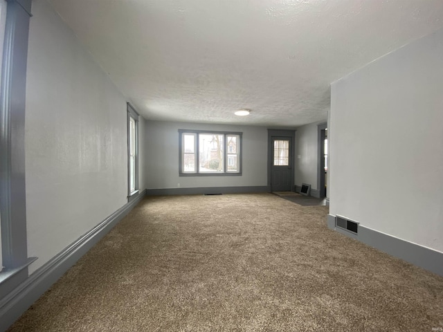 carpeted spare room featuring a textured ceiling