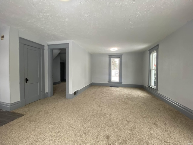 carpeted spare room featuring a textured ceiling