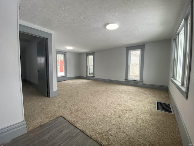 spare room featuring carpet and a textured ceiling