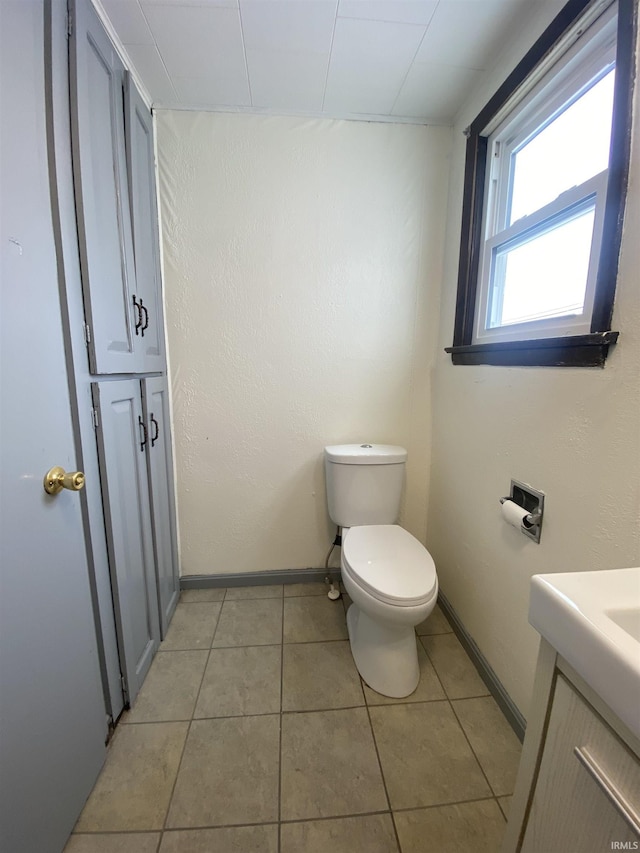 bathroom with toilet, tile patterned flooring, and vanity