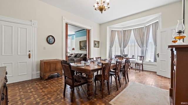 dining space with a chandelier and dark parquet floors