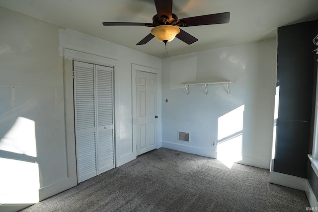 unfurnished bedroom featuring ceiling fan, carpet, and two closets