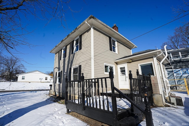 snow covered back of property with central air condition unit