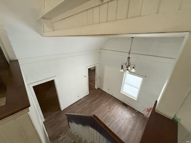 entrance foyer featuring an inviting chandelier, dark hardwood / wood-style flooring, and lofted ceiling