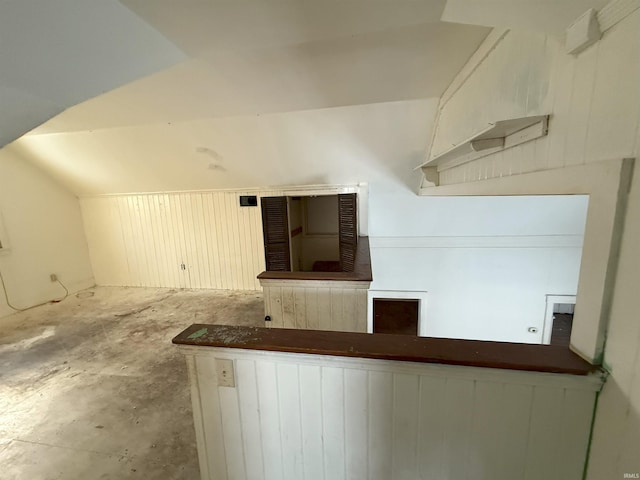 interior space featuring concrete flooring and vaulted ceiling