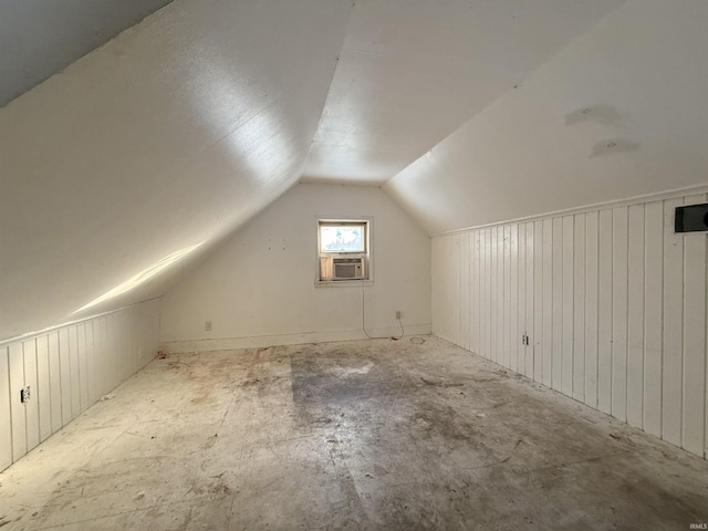 additional living space featuring cooling unit and lofted ceiling