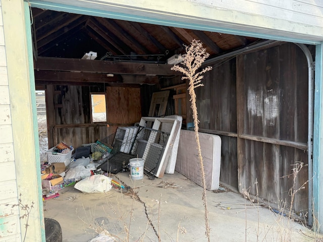 miscellaneous room featuring wood walls and lofted ceiling