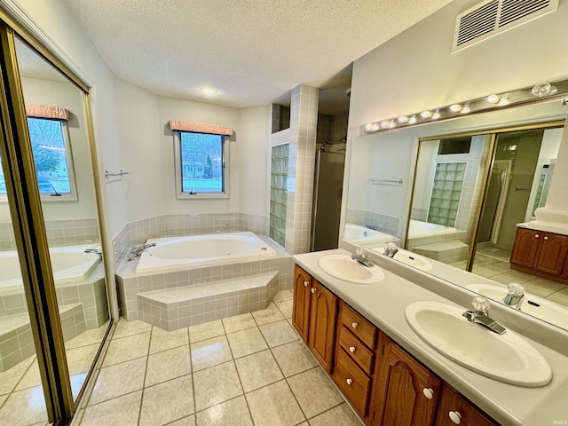 bathroom with vanity, tile patterned floors, a textured ceiling, and plus walk in shower