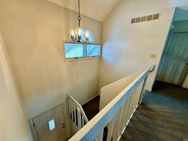 staircase with vaulted ceiling, a chandelier, and carpet flooring