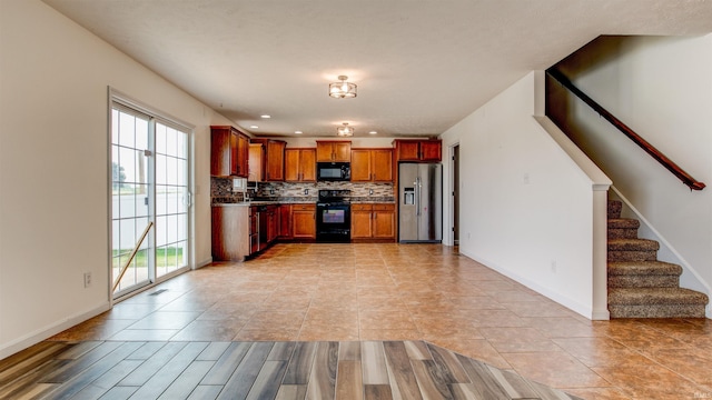 kitchen featuring sink, black appliances, and decorative backsplash