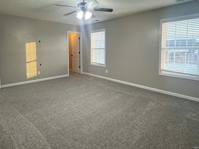 spare room featuring ceiling fan, carpet flooring, and a healthy amount of sunlight