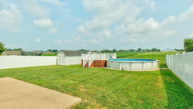 view of yard featuring a swimming pool side deck and a storage unit