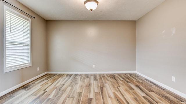 unfurnished room featuring light wood-type flooring and a wealth of natural light