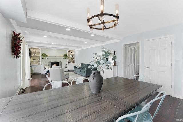 dining area featuring a fireplace, dark wood-type flooring, beam ceiling, and a notable chandelier