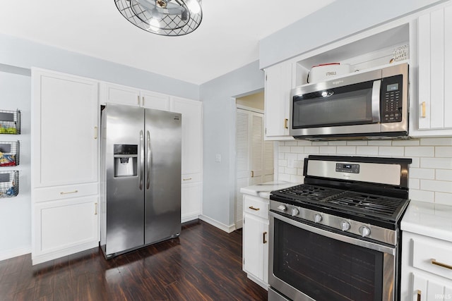 kitchen with backsplash, white cabinetry, appliances with stainless steel finishes, and dark hardwood / wood-style flooring