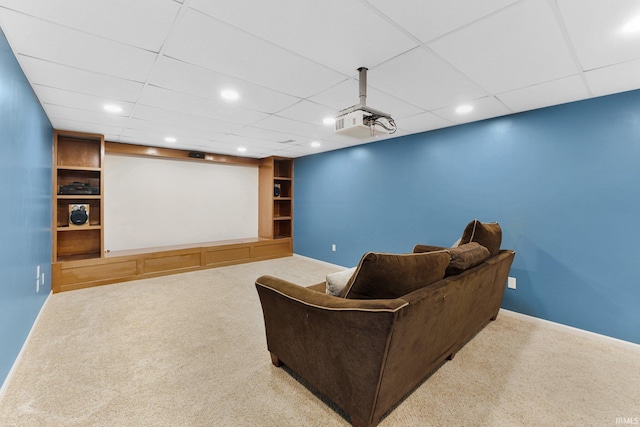 carpeted home theater with a drop ceiling