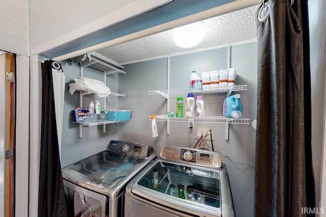 clothes washing area featuring washer and dryer and a textured ceiling