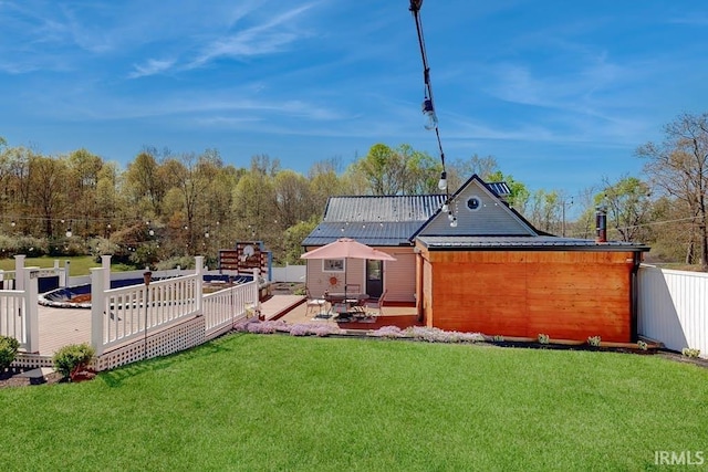 back of house featuring a deck and a lawn