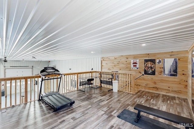 workout room featuring hardwood / wood-style floors and wood walls