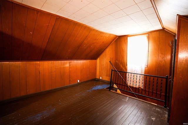 additional living space with dark wood-type flooring and vaulted ceiling