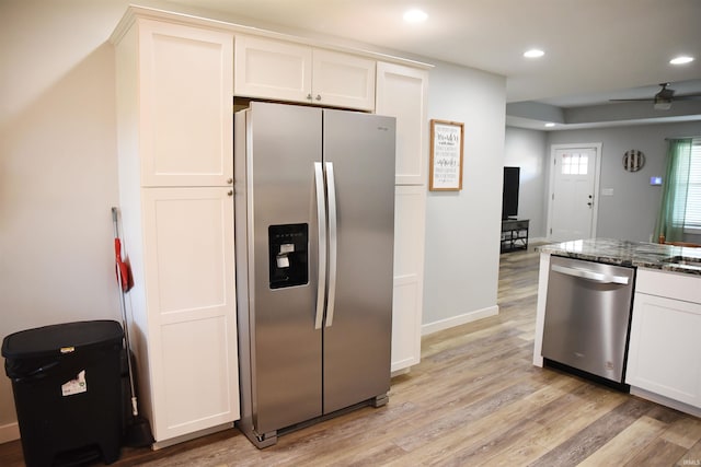 kitchen with ceiling fan, white cabinetry, dark stone counters, light hardwood / wood-style floors, and stainless steel appliances