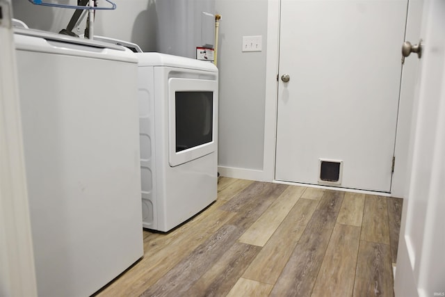 clothes washing area featuring light wood-type flooring and water heater