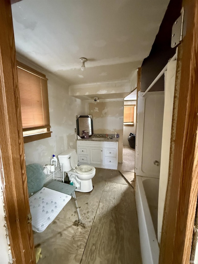 bathroom featuring toilet, a shower, and vanity