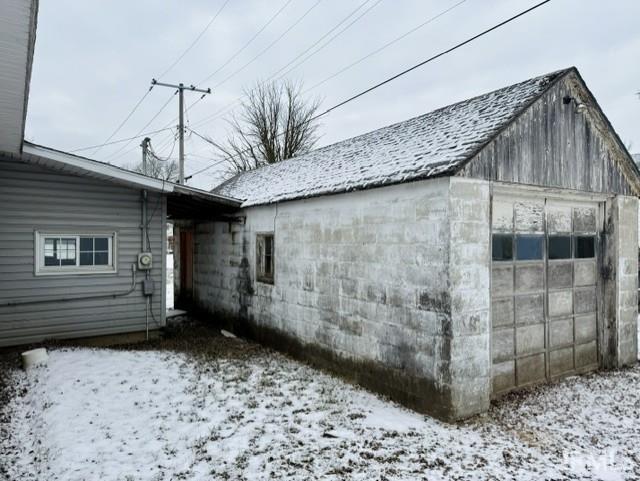 view of snow covered exterior with a garage