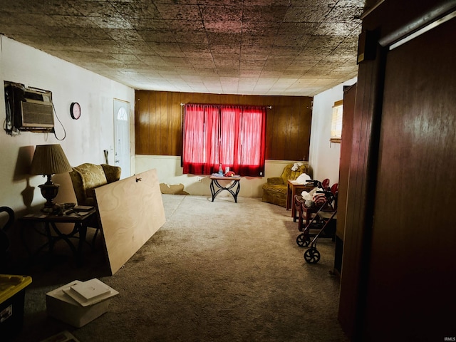 living room featuring carpet floors, wood walls, and a wall mounted AC