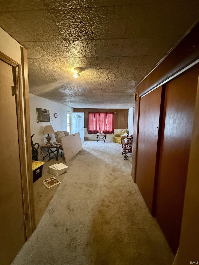 hall with an AC wall unit and carpet flooring