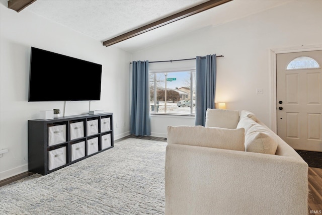 living room featuring hardwood / wood-style floors, a textured ceiling, and vaulted ceiling with beams