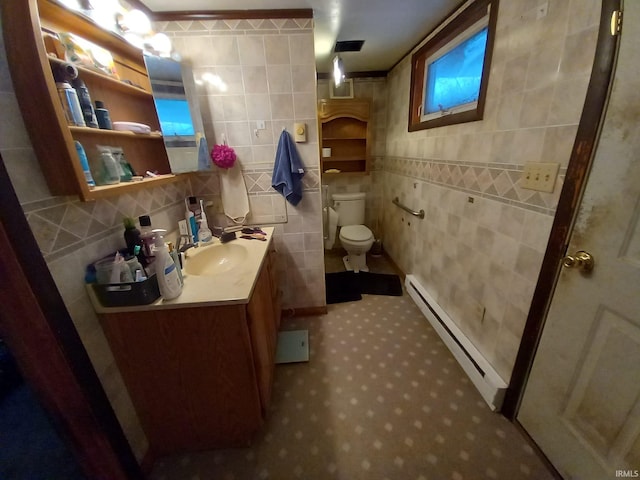 bathroom with vanity, toilet, tile walls, and a baseboard heating unit