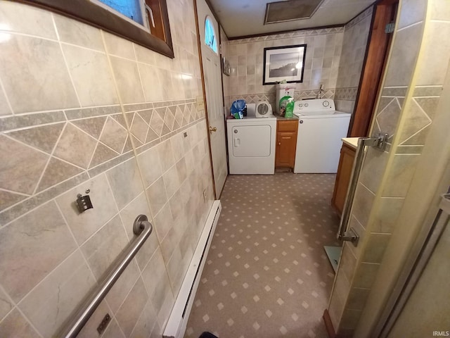 washroom with washing machine and clothes dryer, tile walls, and a baseboard heating unit