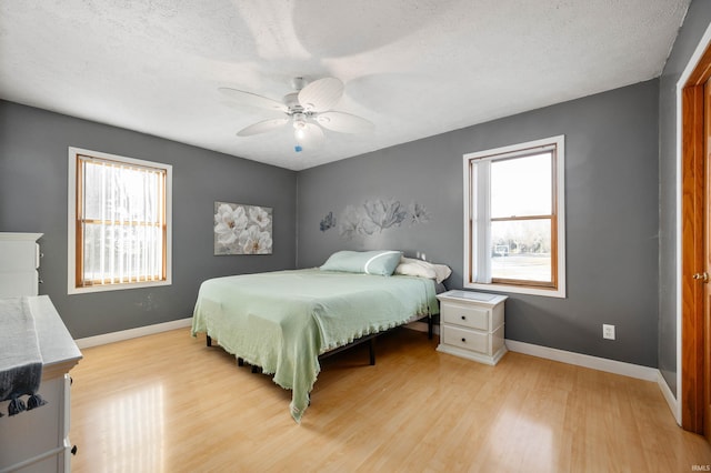 bedroom featuring a textured ceiling, ceiling fan, and light hardwood / wood-style floors